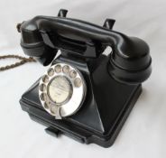 A black bakelite telephone, handset marked P.L 32/234, G.P.O. No.