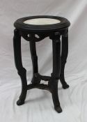 A Chinese hardwood jardiniere stand with an inset marble top above a pierced frieze on shaped legs,