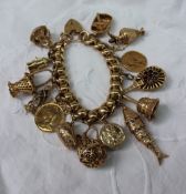 A 9ct yellow gold charm bracelet, set with numerous charms including a miners lamp, coracle,