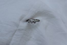 A three stone diamond ring set with three round old cut diamonds each approximately 0.