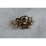 A 9ct yellow gold and pearl set bar brooch in the form of a bow