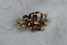 A 9ct yellow gold and pearl set bar brooch in the form of a bow