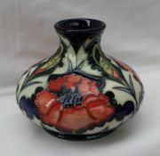 A Moorcroft pottery vase of squat form decorated in the poppy design,