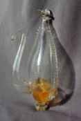 A 19th Century clear glass water barometer, with a moulded suspension loop and long slender spout,