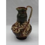 A Mark V Marshall for Doulton Lambeth pottery ewer with a flared rim, with a stylised leaf handle,