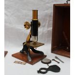 A lacquered brass and Japanned monocular microscope in a mahogany case with lens etc