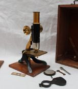 A lacquered brass and Japanned monocular microscope in a mahogany case with lens etc