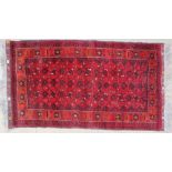 A red ground Beshir type rug, with interlaced geometric flowers within a border of stylised flowers,