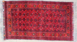 A red ground Beshir type rug, with interlaced geometric flowers within a border of stylised flowers,