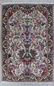 A Tabriz wool and silk rug, with a central vase of flowers with a bird border to a cream ground,