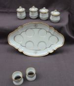 A 19th century French porcelain tray of oval lobed form on a pedestal foot with four pots de creme