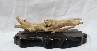 An early 20th century Japanese figure group of a lion attacking a crocodile with mother of pearl
