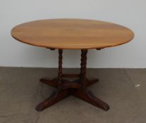 A 20th century oak supper table, the circular top with a tilt action on four barley twist legs,