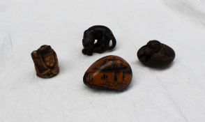 A Japanese hardwood netsuke in the form of a prowling tiger,