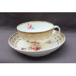 A Derby porcelain tea cup and saucer, with a scrolling gilt border,