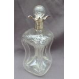 An Edwardian silver topped and engraved glass decanter, with a flared rim, and a pinched glass body,