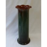 A Linthorpe pottery vase of cylindrical form with a flared rim and mottled green glaze,
