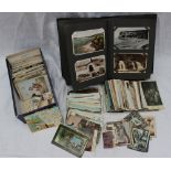 A postcard album and a box of loose postcards and cigarette cards,