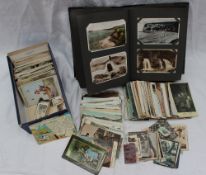 A postcard album and a box of loose postcards and cigarette cards,