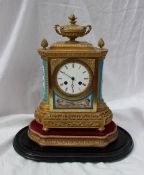 A 19th century French ormolu and porcelain clock, with a vase and pineapple finials,
