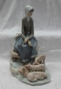A Lladro figure of a maiden seated upon a rocky outcrop with pigs at her feet, impressed mark, 27.