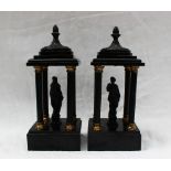 A pair of black slate and metal figural pillars, probably originally part of a clock garniture,