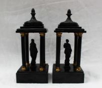 A pair of black slate and metal figural pillars, probably originally part of a clock garniture,