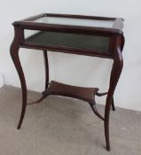 A 20th century mahogany bijouterie cabinet with a hinged glazed top,
