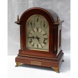 An Edwardian mahogany bracket clock of domed form with quarter stop fluted ionic columns on a