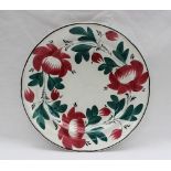 A Davenport pottery plate painted with a version of the Persian rose with green interlinked leaves,