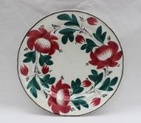 A Davenport pottery plate painted with a version of the Persian rose with green interlinked leaves,