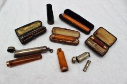 A silver cigar holder, together with 9ct gold and amber mouthpieces,