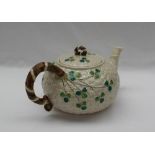 A Belleek porcelain teapot and cover, moulded with a basketweave and shamrock pattern,