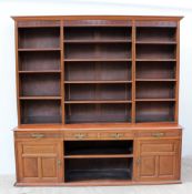 A 20th century mahogany bookcase, the moulded cornice above a dentil cornice and open shelves,
