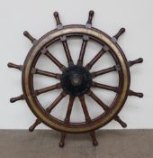 A large brass and hardwood ships wheel, with twelve spokes,