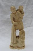 A 19th century Japanese carved ivory figure of a fisherman with a child on his back,