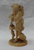 A late 19th century Oriental carved ivory figure holding a basket over his shoulder in his left