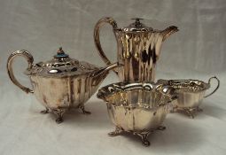 An Edwardian silver three piece tea set, comprising a teapot with enamel decorated finial,