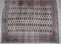 A large Turkoman carpet, with a light red ground and fringed border,