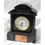 A George V black slate mantle clock of architectural form with a domed top with a blind frieze,