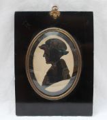 A 19th century cut card silhouette of a lady in a hat, tied with a bow, oval,