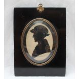 A 19th century cut card silhouette of a lady in a hat, tied with a bow, oval,