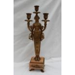 A gilt metal candleabra in the form of a maiden,