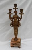 A gilt metal candleabra in the form of a maiden,