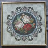 A stump, wool and beadwork picture of roses in a roundel,