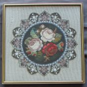 A stump, wool and beadwork picture of roses in a roundel,