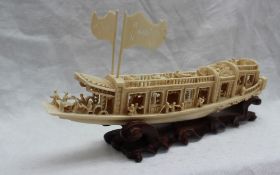 An early 20th century Chinese carved ivory boat, profusely carved with figures, rails and door,