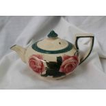 A Llanelly pottery teapot painted with red roses and leaves to green line decoration,