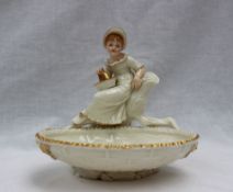 A Royal Worcester bon bon dish, with a basket in the foreground and young girl above,