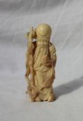 A Japanese Ivory figure depicting Shou Lao, holding a staff and peach, 8.